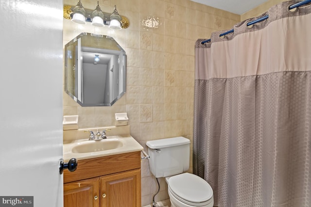 bathroom with tile walls, a shower with curtain, vanity, and toilet