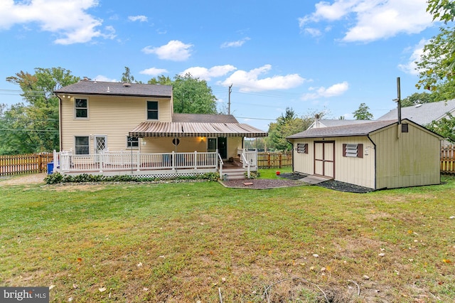 back of property featuring a storage shed, a deck, and a lawn