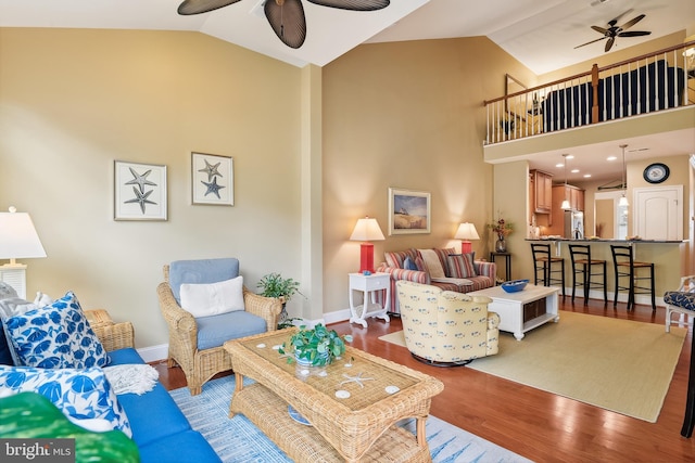 living room featuring hardwood / wood-style flooring, high vaulted ceiling, and ceiling fan