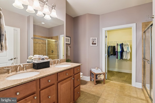 bathroom featuring vanity, a shower with shower door, and tile patterned flooring