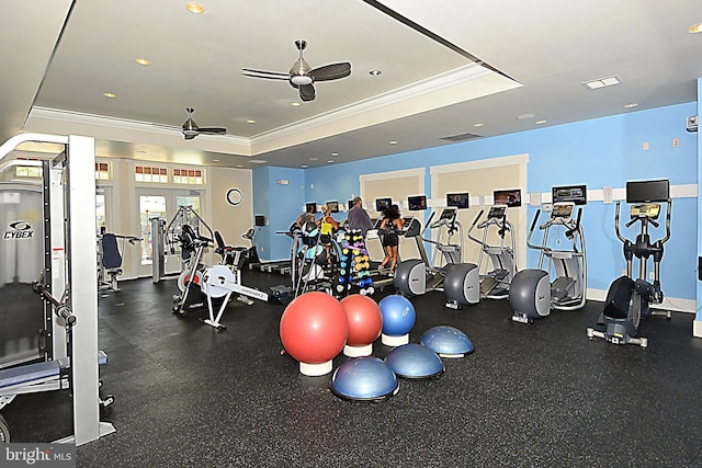 workout area with ceiling fan, crown molding, and a tray ceiling