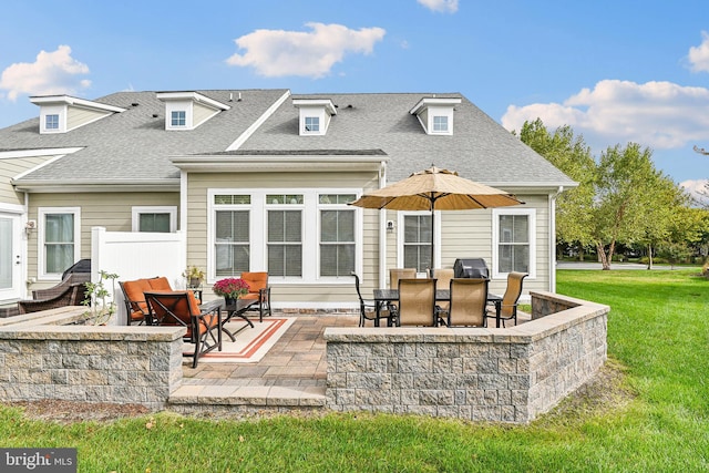 rear view of property featuring a patio and a lawn