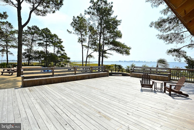 wooden terrace featuring a water view