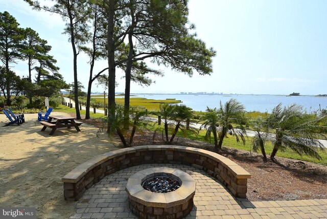 view of patio with an outdoor fire pit and a water view