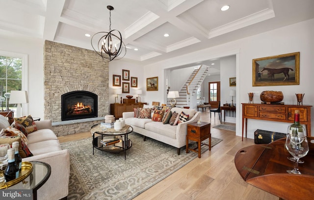 living room featuring a fireplace, a chandelier, light hardwood / wood-style flooring, and a wealth of natural light