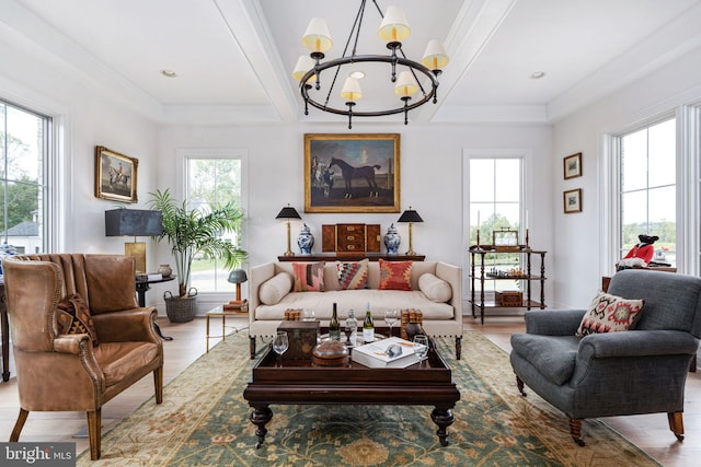 living room featuring ornamental molding, a chandelier, and light hardwood / wood-style floors