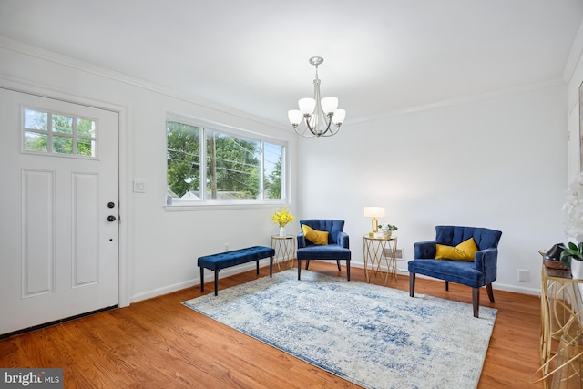 living area featuring crown molding, a chandelier, and hardwood / wood-style flooring