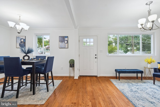 interior space featuring ornamental molding, a chandelier, and light hardwood / wood-style flooring