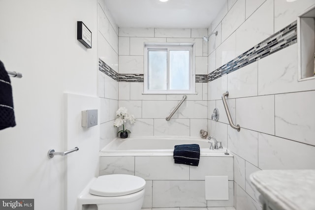 bathroom featuring tiled shower / bath and toilet