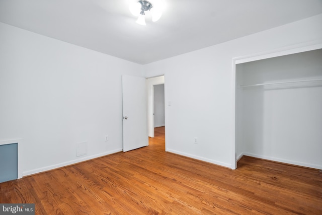 unfurnished bedroom featuring wood-type flooring and a closet