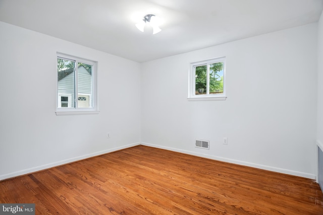 spare room with hardwood / wood-style flooring and a healthy amount of sunlight