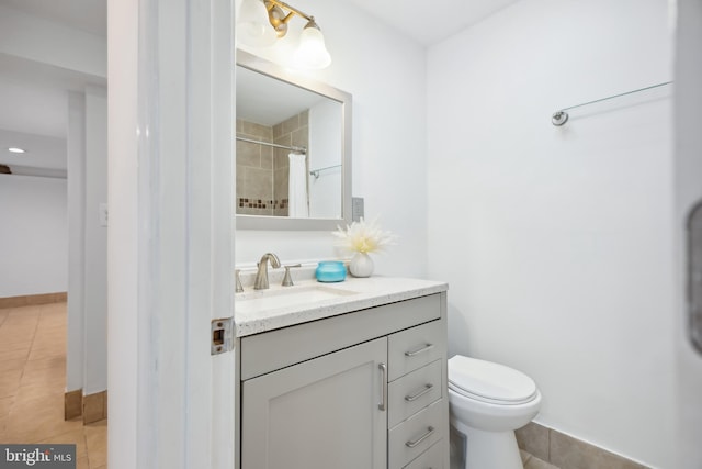 bathroom with tile patterned floors, curtained shower, vanity, and toilet