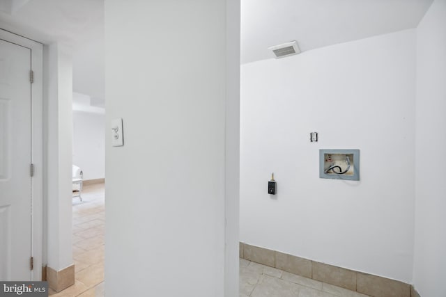 clothes washing area featuring washer hookup and light tile patterned floors