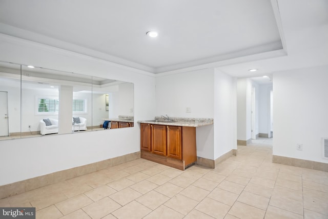 interior space with light tile patterned flooring, ornamental molding, and sink