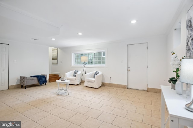 sitting room with crown molding and light tile patterned floors