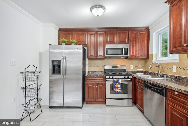 kitchen with appliances with stainless steel finishes, dark stone counters, backsplash, and sink