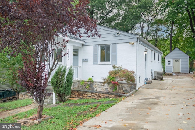 view of front of house with cooling unit and a storage shed