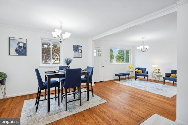 dining space featuring light wood-type flooring, a chandelier, and crown molding