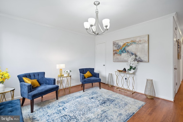 sitting room featuring wood-type flooring, crown molding, and an inviting chandelier