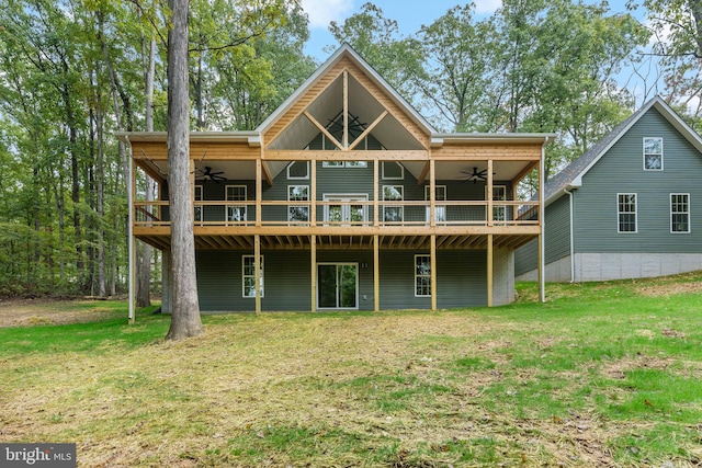 back of house featuring a lawn, ceiling fan, and a deck