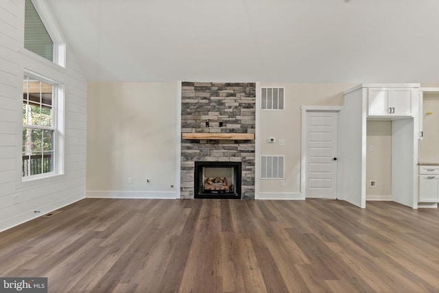 unfurnished living room featuring vaulted ceiling, dark hardwood / wood-style floors, and a fireplace