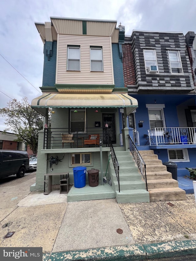 townhome / multi-family property with cooling unit and covered porch