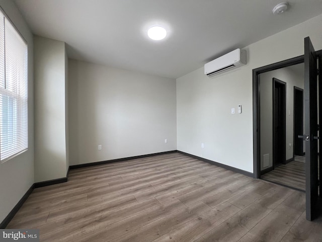 spare room featuring hardwood / wood-style flooring and a wall mounted AC