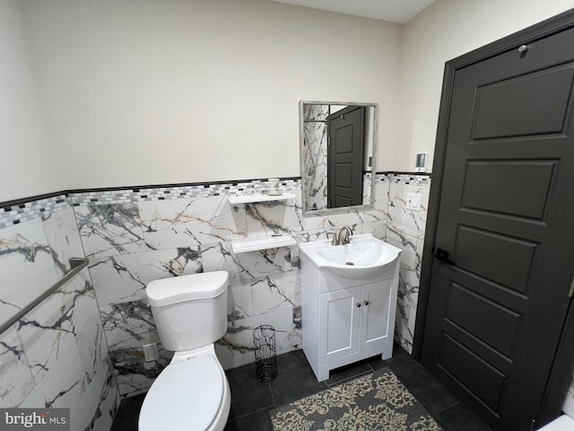 bathroom featuring vanity, tile walls, toilet, and tile patterned floors