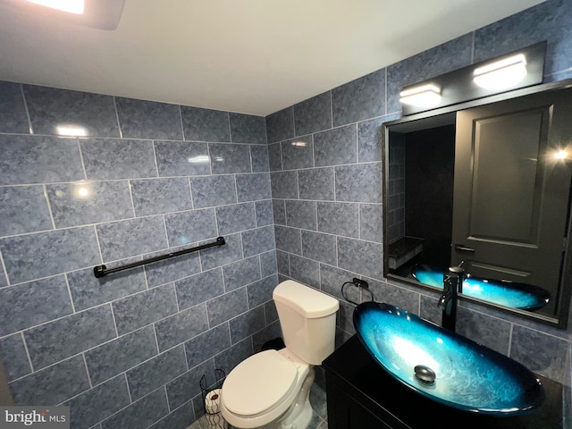 bathroom featuring vanity, tile walls, backsplash, and toilet