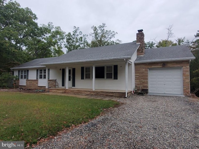 ranch-style house featuring covered porch, a front lawn, and a garage