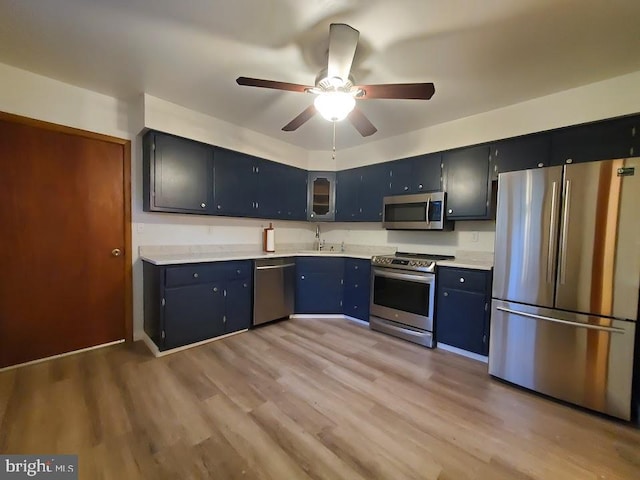 kitchen featuring sink, appliances with stainless steel finishes, light hardwood / wood-style floors, and ceiling fan