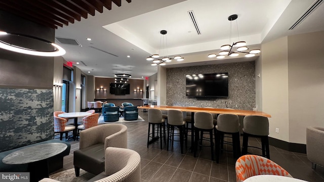 interior space with a tray ceiling and bar