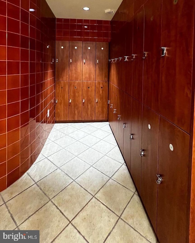 corridor with tile walls and tile patterned flooring