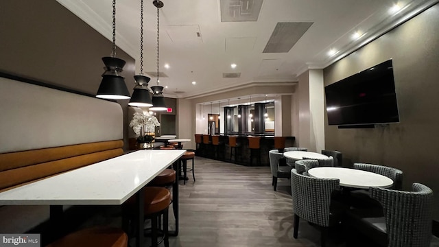 dining area featuring hardwood / wood-style floors and ornamental molding