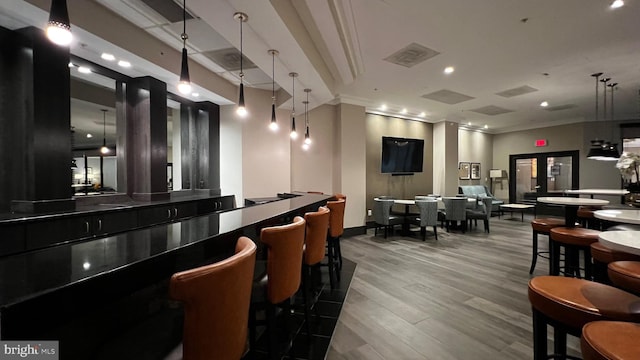 bar with pendant lighting, hardwood / wood-style flooring, and crown molding