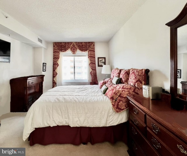 carpeted bedroom featuring a textured ceiling