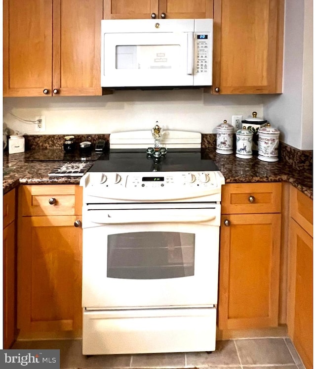 3101 N Hampton Dr Unit 814, Alexandria, VA 22302 - kitchen with white appliances, dark stone counters, and brown cabinetry