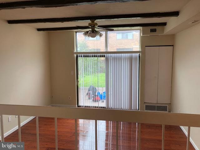 unfurnished room with ceiling fan, beamed ceiling, and hardwood / wood-style flooring