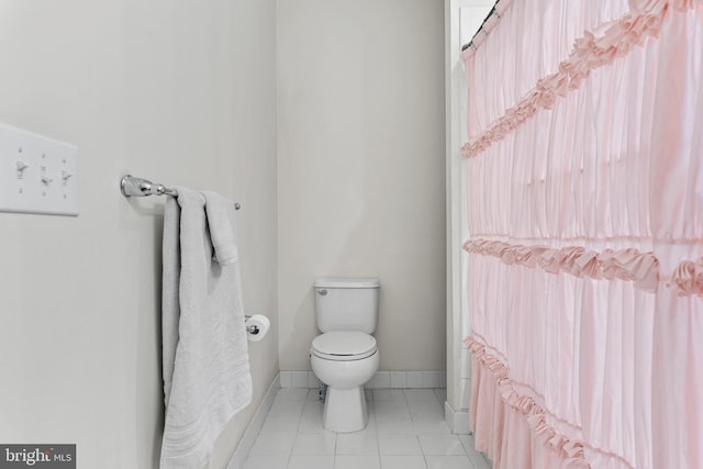 bathroom featuring tile patterned floors, toilet, and a wealth of natural light