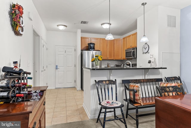 kitchen with kitchen peninsula, a breakfast bar, stainless steel appliances, hanging light fixtures, and light tile patterned flooring