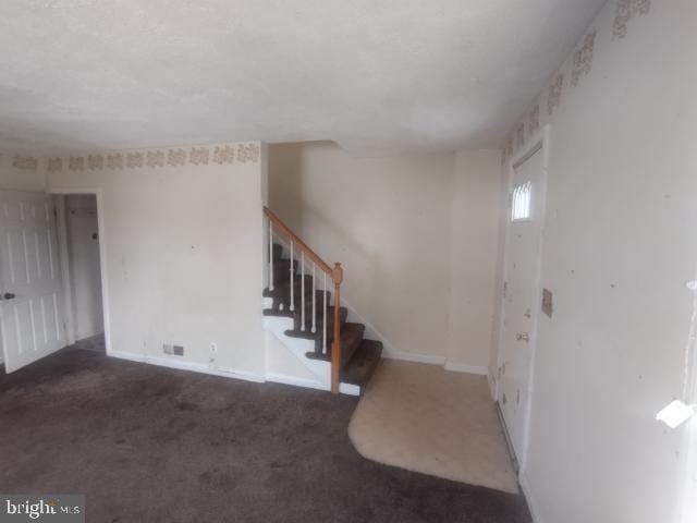 foyer with dark colored carpet