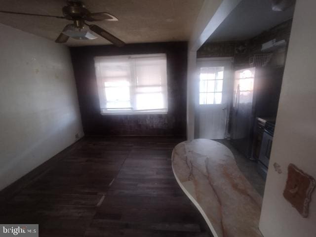 unfurnished room with ceiling fan and dark hardwood / wood-style flooring