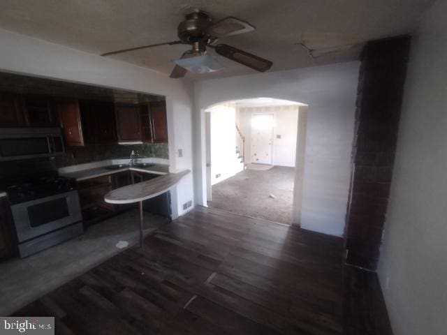 kitchen featuring ceiling fan, dark hardwood / wood-style floors, and white gas range oven