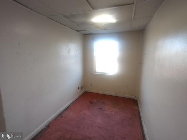 carpeted spare room featuring a paneled ceiling