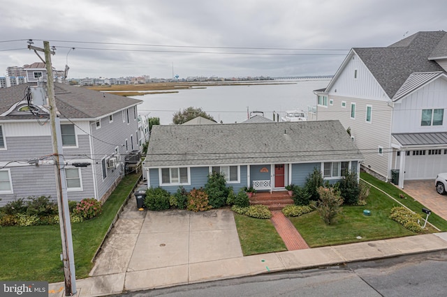 view of front of home with a garage, covered porch, a front lawn, and a water view