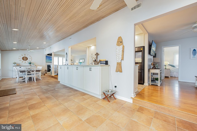 interior space featuring wood ceiling, white cabinets, vaulted ceiling, light hardwood / wood-style flooring, and ceiling fan