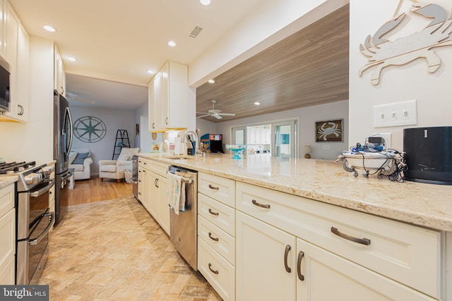 kitchen featuring light stone counters, range with gas cooktop, dishwasher, ceiling fan, and sink