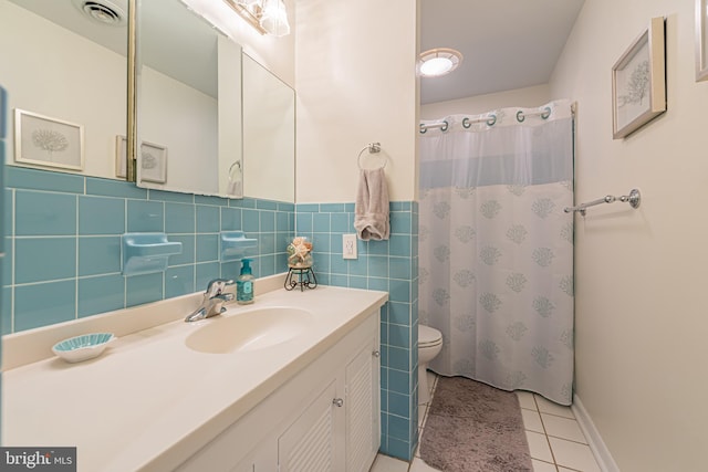 bathroom featuring vanity, toilet, walk in shower, tile walls, and tile patterned flooring