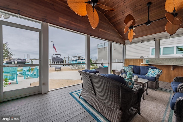 sunroom / solarium with wood ceiling, a wealth of natural light, lofted ceiling, and ceiling fan