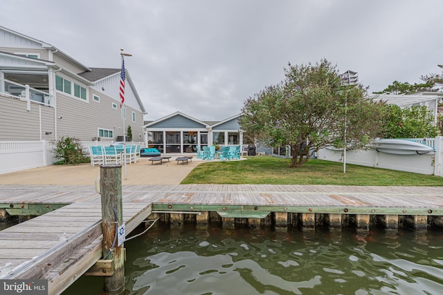 dock area featuring a lawn, a water view, and a patio area